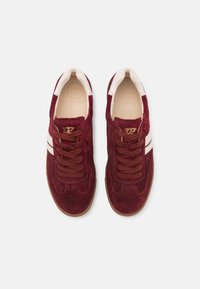 Bordeaux suède sneakers met witte strepen, ronde neus, bruine veters en een gestructureerde rubberen zool. "SUPER SOFT" is in de binnenzool geperst.