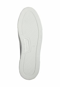 Baskets noires avec une semelle blanche en caoutchouc présentant un motif texturé, des bords lisses et un nom de marque en relief sur la semelle intermédiaire.