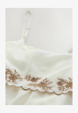 Crèmekleurige linnen top met verstelbare bandjes, voorzien van gedetailleerde beige bloemenborduring langs een geschulpte zoom. Zachte textuur en lichtgewicht.