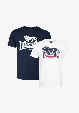 Dos camisetas exhibidas: una azul marino con un gráfico de león y logotipo, y la otra blanca con un gráfico de león negro y detalles rojos.