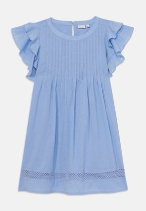 Robe en coton bleu clair avec des manches volantées, des plis verticaux sur le corsage et une bordure en dentelle au bas. Fermeture à boutons au dos.