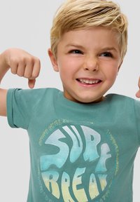 Grünes Baumwoll-T-Shirt mit einem großen, bunten "SURF BREAK"-Grafikdesign und strukturierten Buchstaben. Kurzärmlig und mit einem runden Ausschnitt.