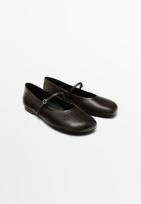 Black leather ballet flats with a rounded toe, thin strap across the instep, and a smooth, shiny texture. Flat sole; no visible patterns.
