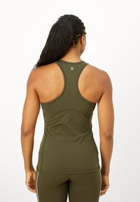 Camisola de desporto verde-azeitona com design de costas nadador, feita de material elástico, apresentando costuras curvas e um pequeno logo nas costas.