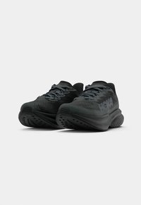 Svarte joggesko med teksturert mesh-overdel, polstret krage og tykk såle med flere spor og ventilasjonshull.