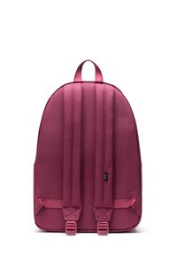 Sac à dos en tissu texturé bordeaux, de forme arrondie, avec des straps rembourrés, des poches latérales et deux boucles à la base.