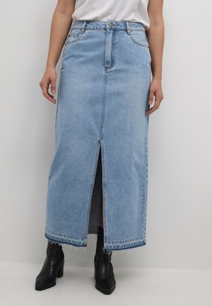 Light blue denim maxi skirt with a front slit, frayed hem, and five-pocket design, worn with black ankle boots.
