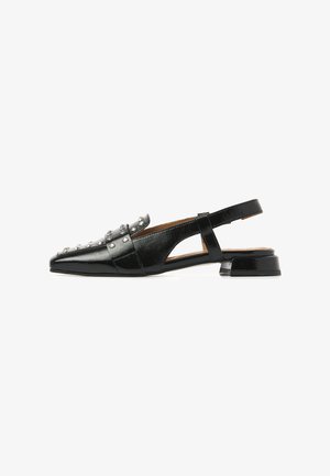 Black patent leather slingback flat shoe with silver studs and a low block heel, shown from the side on a white background.