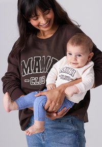 Brūna kapuce ar "MIAMI CLUB" drukājumu, gaiši pelēks bērnu džemperis un zili legingi. Ikdienišķi, mīksti audumi; brīva piegriezuma abiem.