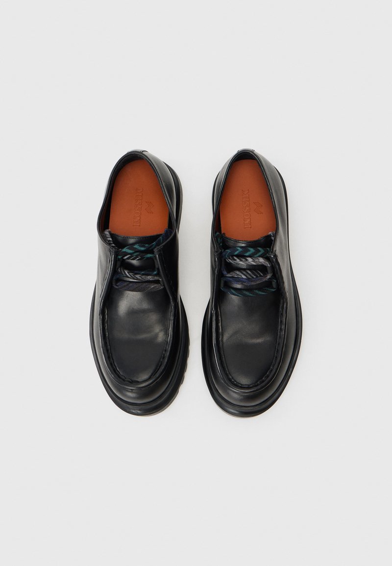 Sorte lædersko med rund tå, kontrasterende flerfarvede snørebånd og en glat, skinnende finish. Har en polstret krave.