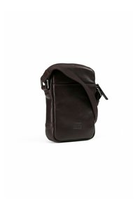 Bolso cruzado de cuero marrón con una textura suave, forma rectangular, correa ajustable, cierre de cremallera y un detalle en el bolsillo frontal.