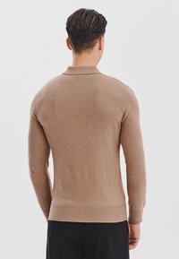 Brązowy sweter dzianinowy z długimi rękawami, kołnierzykiem i ściągaczami. Gładka faktura, dopasowany krój oraz jednolity kolor bez widocznych wzorów.