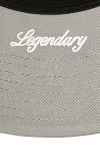 Grauem Stoffhut mit einer Krempe und dem weiß gestickten Wort "Legendär" in geschwungener Schrift.