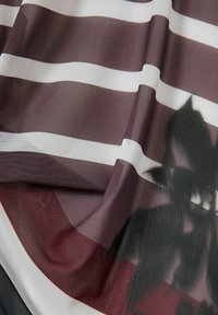Prugasta tkanina sa širokim horizontalnim prugama u burgundiji i bijeloj, s teksturiranim tkanjem. Senčna šablona dodaje dubinu dizajnu.