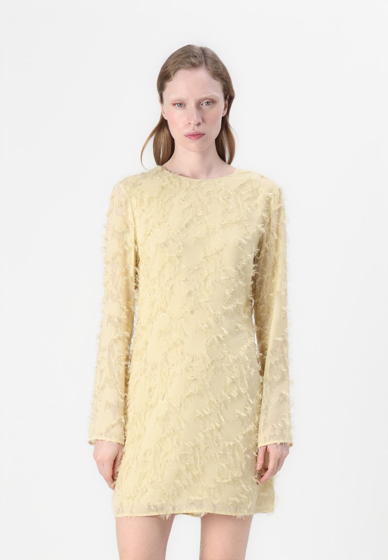 Gelbes Kleid mit langen, durchsichtigen Ärmeln, das ein strukturiertes, ausgefranstes Muster aufweist. Die Silhouette ist figurbetont mit einem runden Ausschnitt.