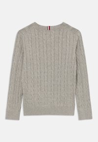 Grå kabelstrikket genser med lange ermer, ribbet rund hals og nederste kant. Har en stripete aksent rundt halsen i rødt, hvitt og blått.