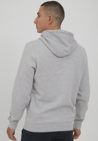 Grijze hoodie met een ontspannen pasvorm, met een capuchon met trekkoord, ribgebreide manchetten en een gladde textuur. Ontworpen voor comfort en casual kleding.