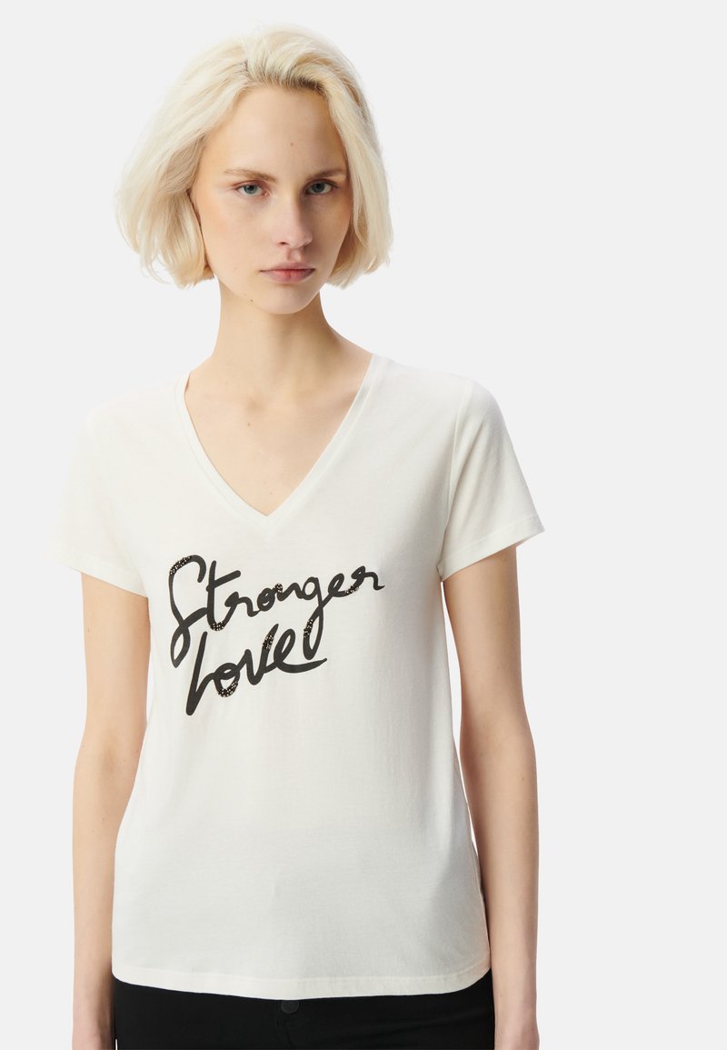 Camiseta de algodón blanca con cuello en V, mangas cortas y un estampado en cursiva negra que dice "Stronger love" en el pecho.