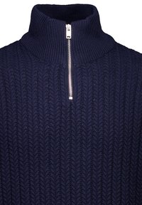 Marineblauer Strickpullover mit hohem Kragen und silbernem Reißverschluss, der ein strukturiertes Fischgrätmuster über den gesamten Körper hat.