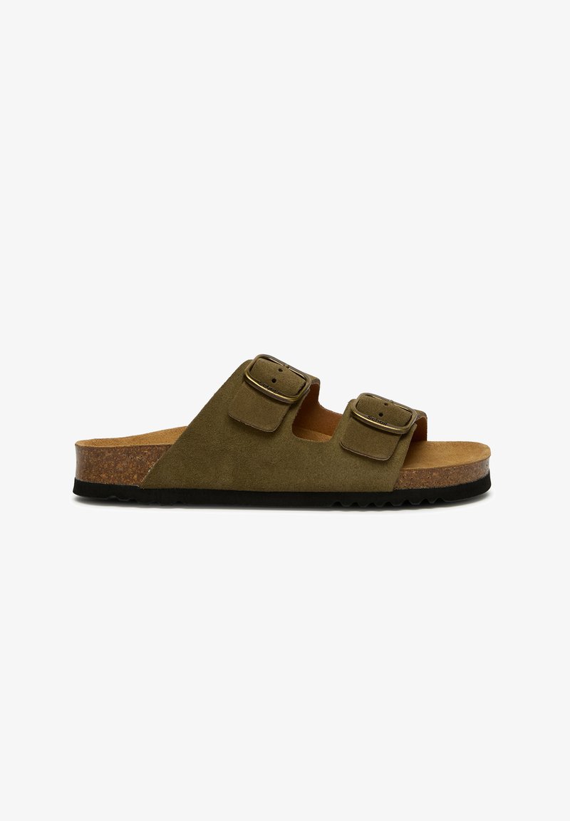 Sandales slip-on en daim vert olive avec deux boucles réglables, une semelle intermédiaire en liège et une semelle extérieure en caoutchouc noir texturée.