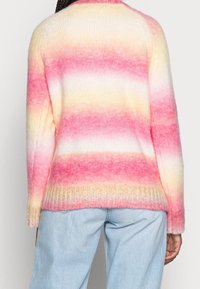 Maglione a maglia ombré rosa e giallo con una texture morbida, orlo a coste e maniche lunghe. La vista dal retro mostra il motivo a gradiente che transita verso il bianco.