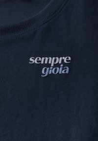 Sweatshirt en coton bleu marine avec un col côtelé et un texte brodé "sempre gioia" dans des nuances variées de blanc et de bleu.