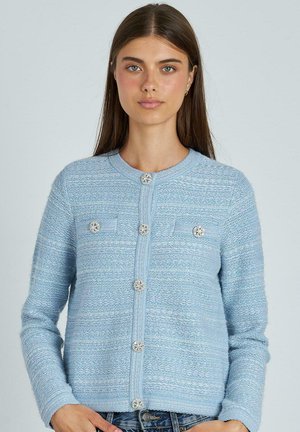 Cárdigan azul claro con un patrón texturizado, cuello redondo y acentos de botones decorativos. Cuenta con dos bolsillos frontales y mangas largas.