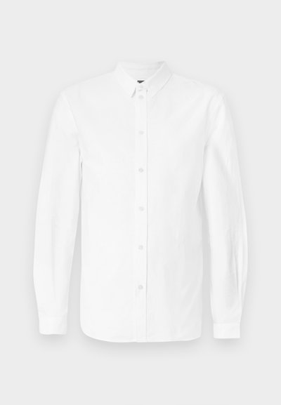 Chemise blanche à manches longues en coton, dotée d'un col boutonné et de boutons sur le devant. Texture lisse avec une coupe classique et sans motifs.