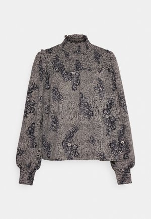 Blouse à manches longues avec col montant à volants, motif floral noir et blanc et pois, poignets froncés.