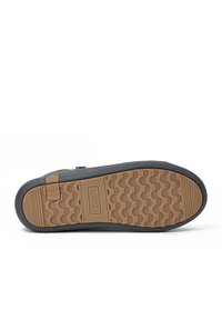 Suela de zapato negra con una suela de goma marrón texturizada que presenta un patrón ondulado. Incluye un logotipo y una lengüeta para facilitar el agarre.