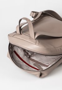 Borsa a mano in pelle beige con chiusura a zip. L'interno presenta accenti rossi, una fodera a motivo e scomparti per l'organizzazione.