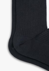 Navyblauwe sokken van ribbelstof met een gladde textuur, voorzien van versterkte tenen en een ribbelboord, plat gelegd tegen een witte achtergrond.