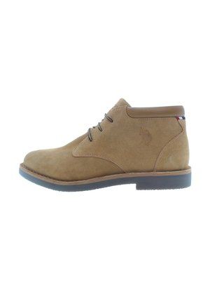 Braune Wildleder-Ankle-Boots mit einem glatten Lederkragen, schwarzen Schnürsenkeln und einer strukturierten Gummisohle, die ein dezentes Logo-Detail an der Ferse aufweist.