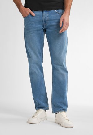 Light blue jeans made of denim, with a straight-leg fit, five pockets, and subtle stitching details. Paired with white sneakers.
