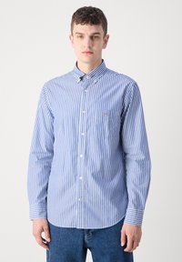 Niebiesko-biała koszula w paski na guziki, z kołnierzykiem, długimi rękawami i kieszenią na piersi. Bawełniana tkanina o gładkiej fakturze.