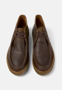 Pair of brown leather casual shoes with dark brown laces and textured rubber soles, shown from a top-down view on a white background.