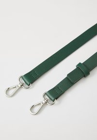 Cintura in pelle verde testurizzata con clip in metallo argentato e un anello in pelle, progettata per un attacco sicuro.