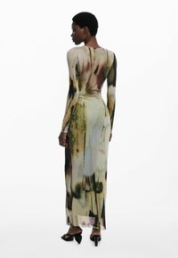Langärmliges Kleid mit floralem Muster in Grüntönen und Braun. Hergestellt aus glattem, dünnem Stoff; figurbetonte Silhouette; knöchellang.