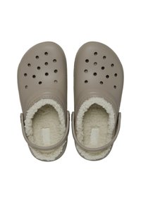 Beige klompen met ventilatiegaten, zachte voering en verstelbare achterkant. Glad buitenoppervlak, platte zool en ronde vorm.