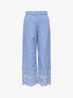 Pantaloni largi, de culoare albastru deschis, cu talie elastică și broderie florală albă de-a lungul tivului lat.