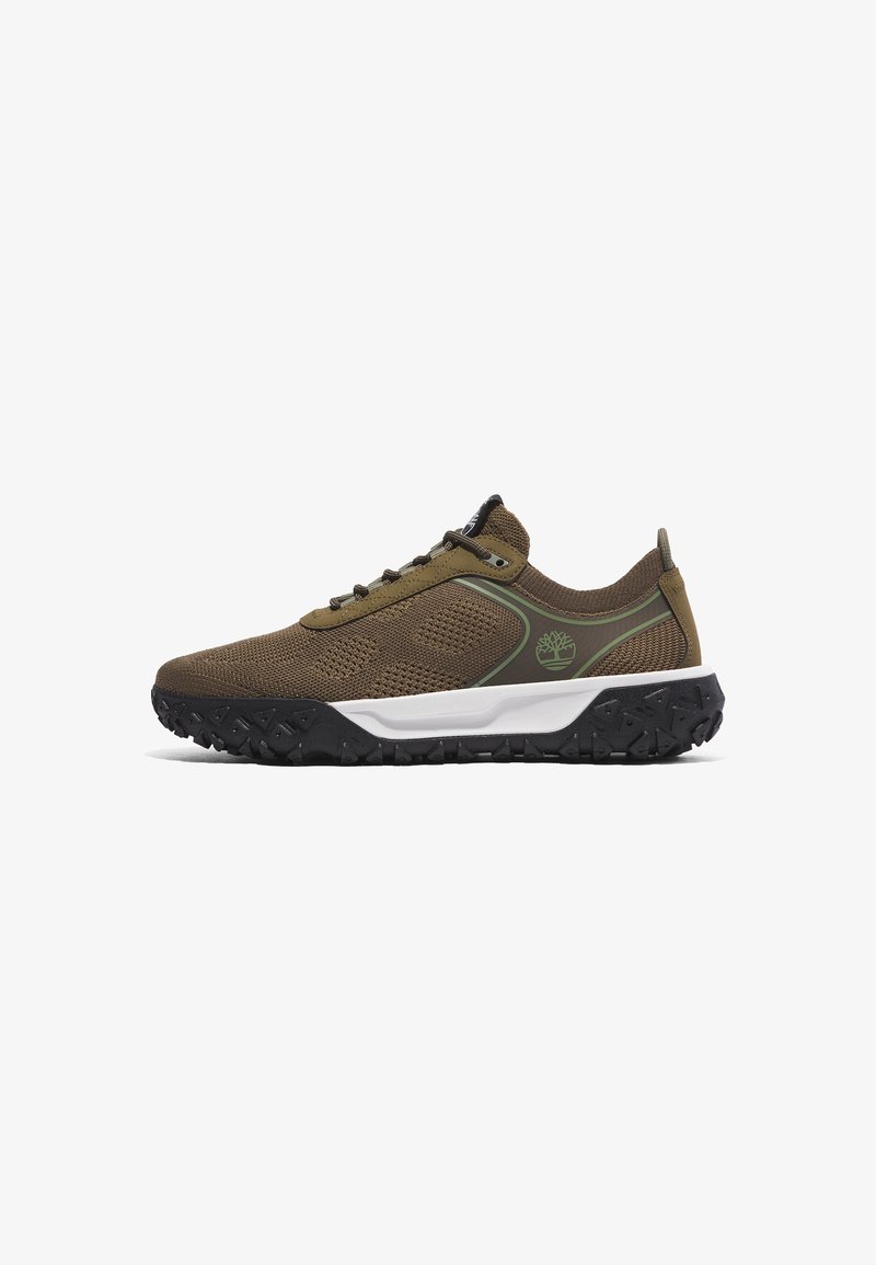 Brown mesh sneakers with a textured upper, green accents, a white midsole, and a black rubber outsole featuring a rugged pattern.