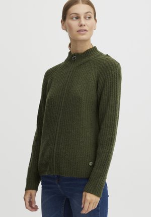 Pull en tricot côtelé vert avec un col haut et une fermeture à boutons à l'avant. Il présente des manches longues et une coupe légèrement raccourcie avec un bouton d'accent sur le côté.