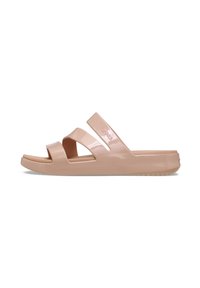 Pale pink slide sandals made of glossy material, featuring two wide, overlapping straps and a textured sole for grip.