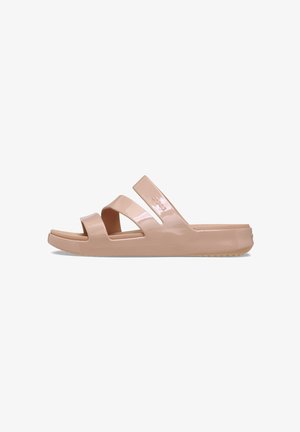Pale pink slide sandals made of glossy material, featuring two wide, overlapping straps and a textured sole for grip.
