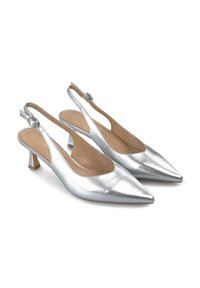 Zapatos de tacón slingback metálicos plateados con punta afilada y un tacón bajo cuadrado. Presentan una hebilla circular en la correa ajustable y una textura suave.