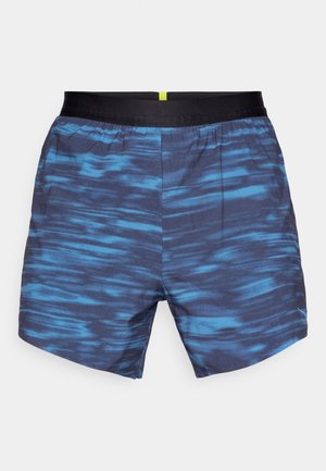 Shorts de bain à motifs bleus, présentant un design ondulé en teintes plus foncées et plus claires, une taille élastique avec une bande noire et un accent jaune.