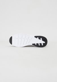 White sneaker sole with textured surface, featuring a black accent and tread pattern designed for traction and stability.