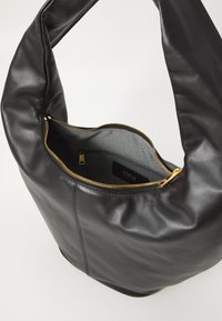 Fekete bőr hobo táska puha textúrával, ívelt formával és felső cipzáros záródással. Aranyszínű fémrészletek és szövetbélelt belső tér.