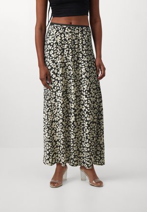 Lang, sort satinnederdel med et cremefarvet blomstermønster. Elastisk talje og flydende silhuet. Båret med gennemsigtige hæle.