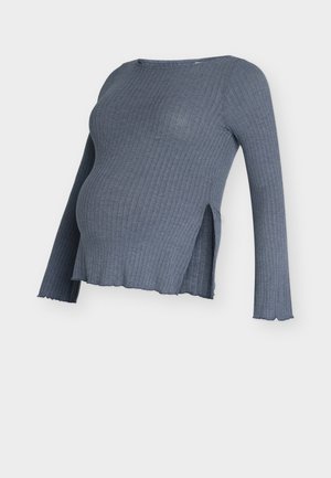 Haut de maternité gris côtelé à manches longues, avec fentes latérales et ourlet courbé. Tissu doux avec une texture apparente.